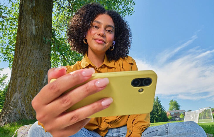 A person looking at their cell phone in a park