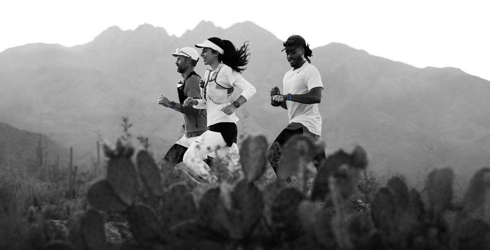 Three people running in a mountainous area, all wearing Apple Watch Ultra 3