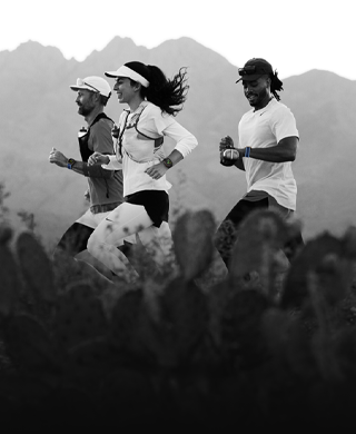 Three people running in a mountainous area, all wearing Apple Watch Ultra 3