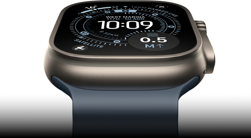 Apple Watch Ultra 3 tilted forward, natural titanium case, compass on Orienteering watch face, anchor blue Ocean Band