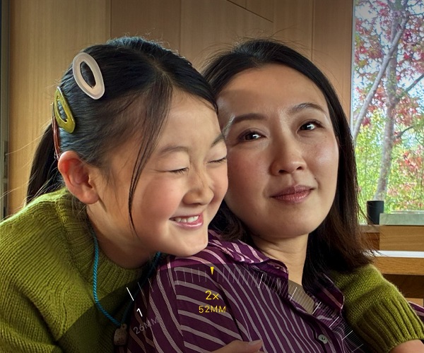 Téléobjectif 2x en cours d’utilisation, zoomant sur deux personnes qui s’enlacent