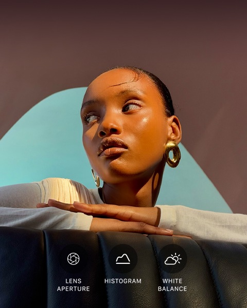 Close up portrait of a well-lit model with a colourful background, demonstrating the pro camera system's Pro controls UI: Aperture, Histogram, White Balance