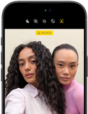 iPhone 18 Pro, black, front exterior, displaying two models posing for the camera, demonstrating the Center Stage front camera