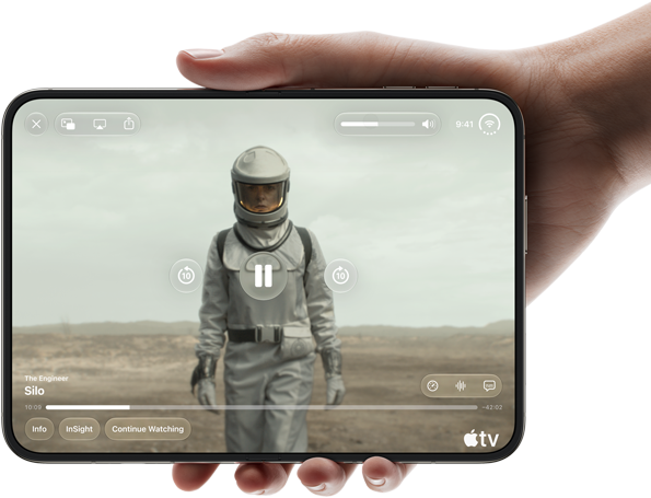 iPhone Duo, held with one hand, opened in horizontal orientation, fully unfolded, interior screen displays Apple TV show "Silo"